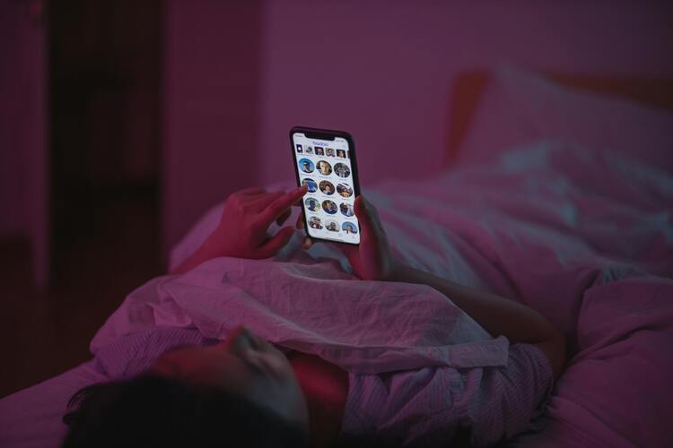 Personne regardant son téléphone dans son lit